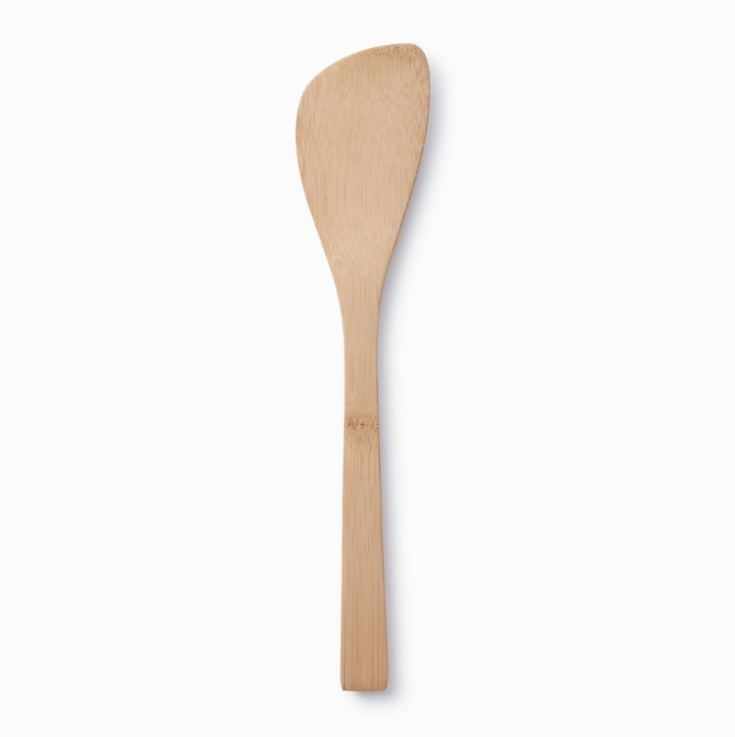 A beige bamboo slotted spoon with a smooth finish.